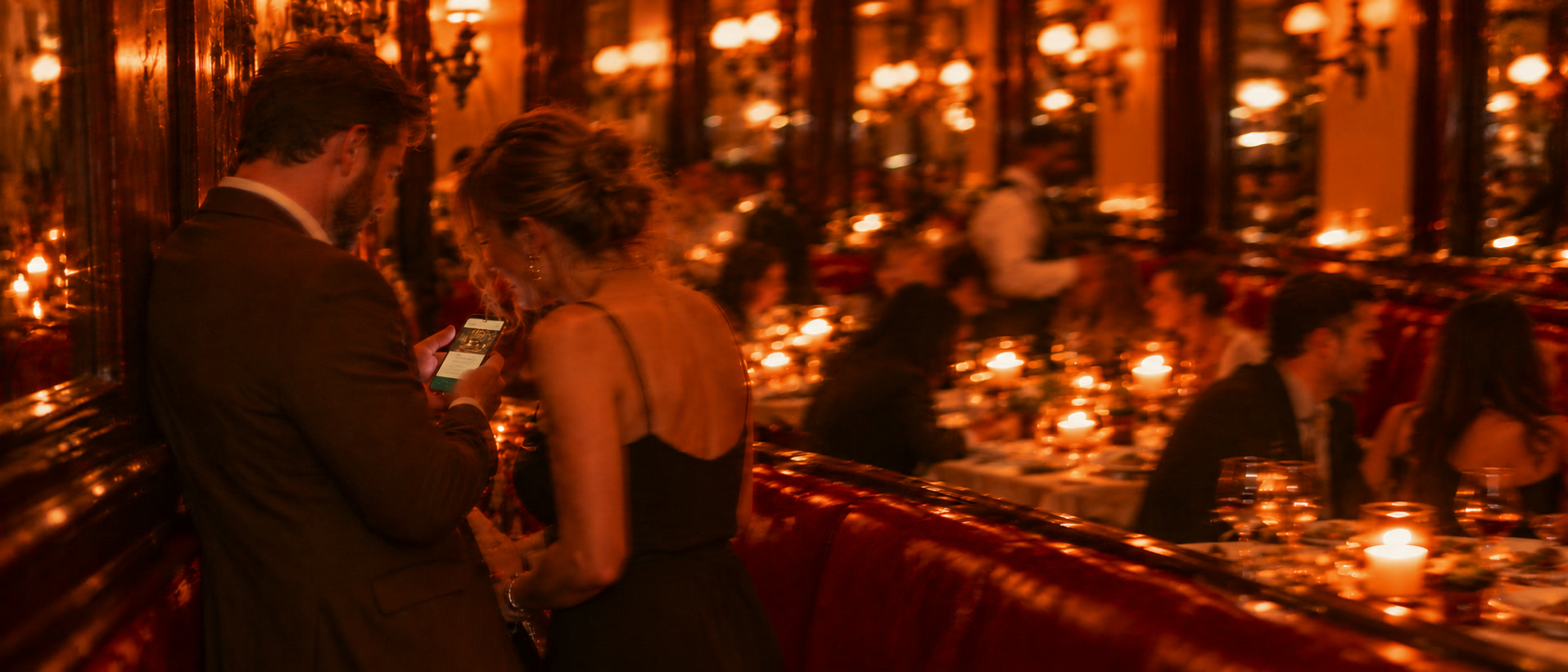 Ein Paar schaut im vollen Restaurant gemeinsam auf eine Nachricht am Handy